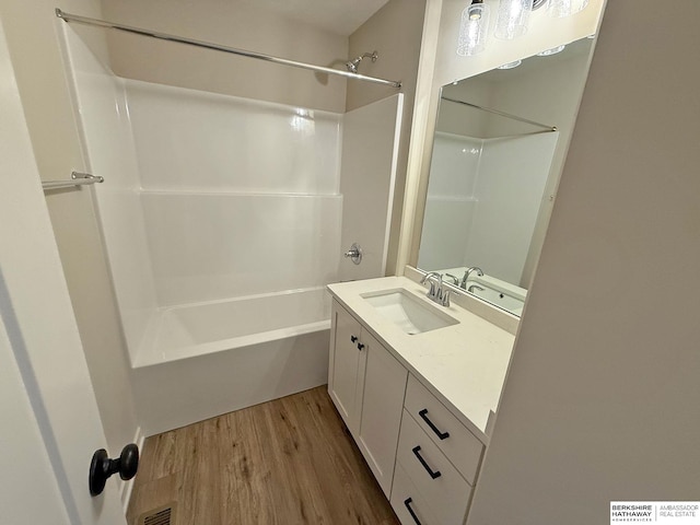 bathroom featuring visible vents, shower / washtub combination, wood finished floors, and vanity