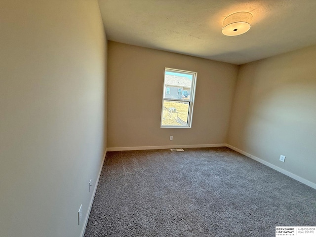 empty room with visible vents, baseboards, and carpet