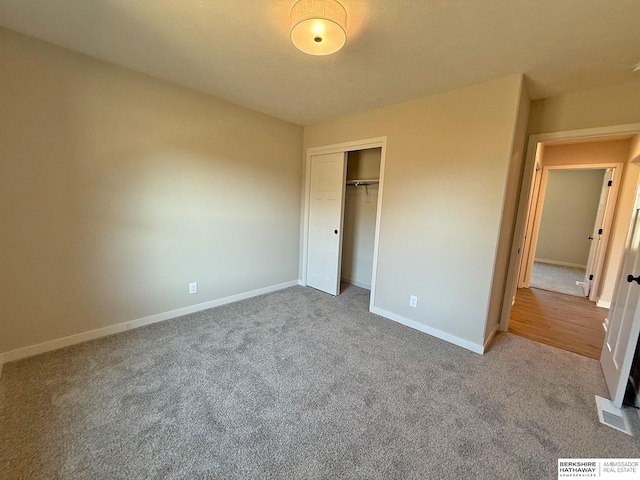 unfurnished bedroom with a closet, visible vents, baseboards, and carpet floors