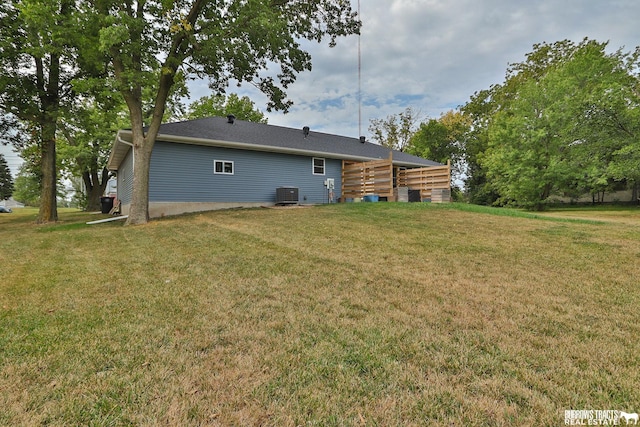 back of property with cooling unit and a lawn