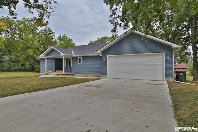 ranch-style house featuring a front yard, driveway, and an attached garage