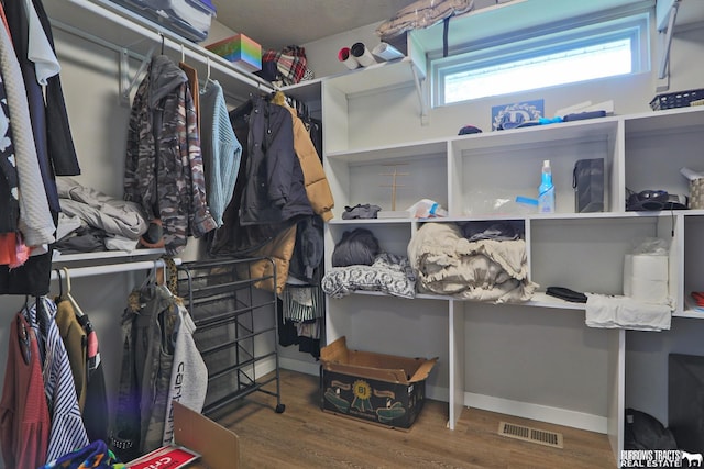 walk in closet with visible vents and wood finished floors