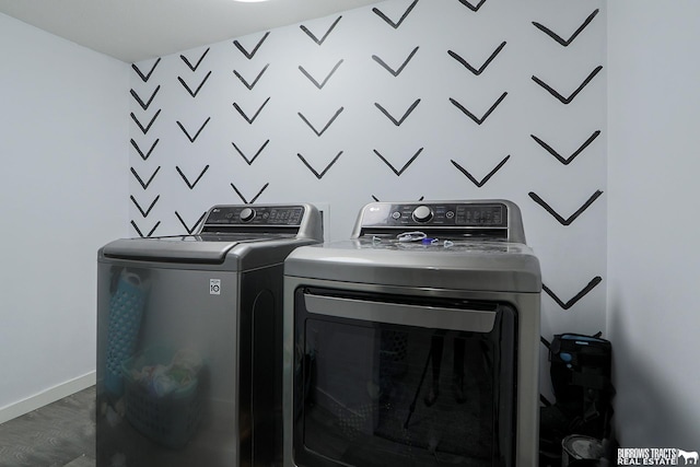 laundry room featuring dark wood-type flooring, laundry area, washer and clothes dryer, and baseboards