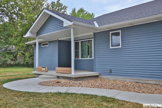 exterior space with a yard and a shingled roof