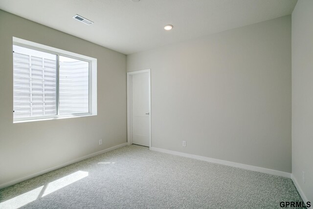 unfurnished room featuring light colored carpet