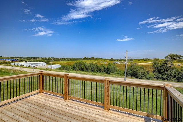 deck with a rural view and a yard