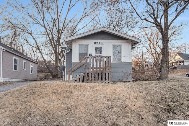 bungalow-style home with a front lawn