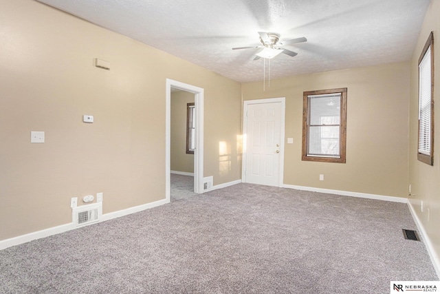 spare room with carpet, a textured ceiling, and ceiling fan