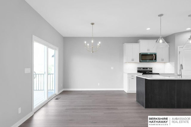 10210 S 110th Ave, Papillion, NE 68046 - kitchen with stainless steel appliances, a chandelier, backsplash, white cabinetry, and wood finished floors