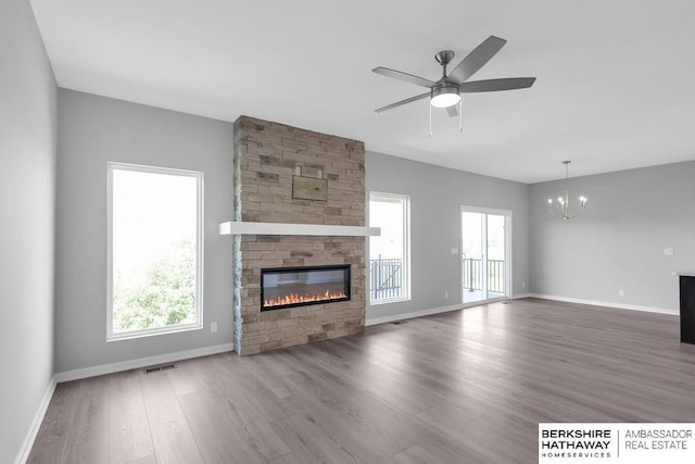 10210 S 110th Ave, Papillion, NE 68046 - unfurnished living room featuring a chandelier, a fireplace, wood finished floors, and a ceiling fan