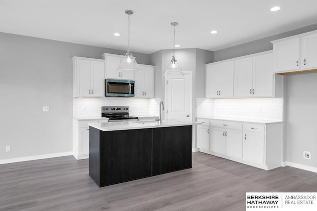 10210 S 110th Ave, Papillion, NE 68046 - kitchen with stainless steel microwave, range with electric cooktop, white cabinetry, backsplash, and recessed lighting