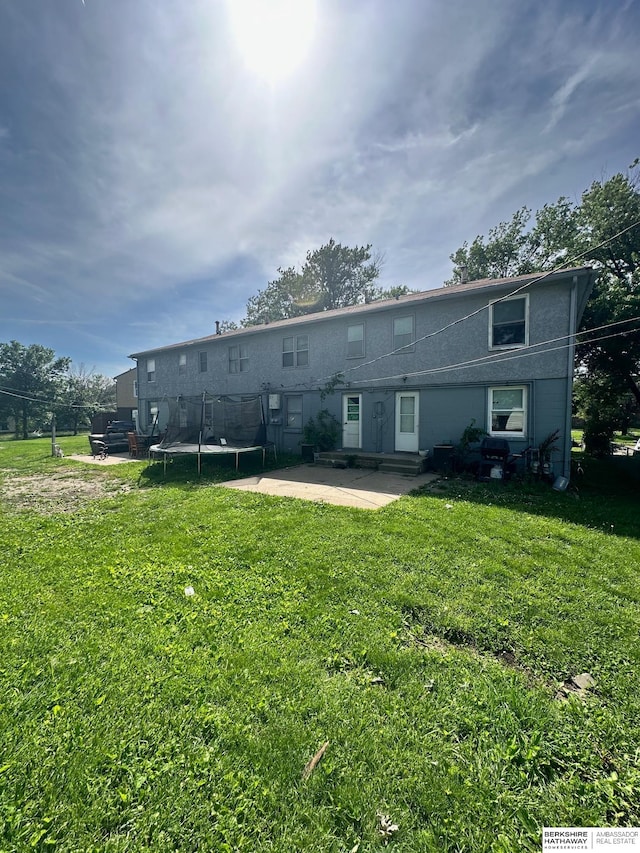 rear view of property featuring a patio and a yard