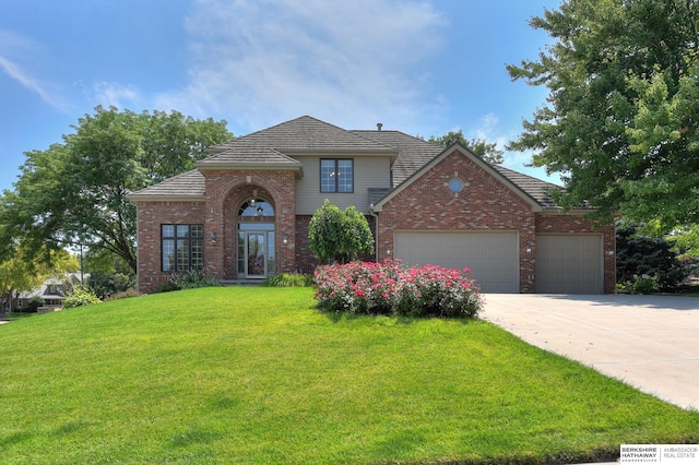 view of front of house featuring a garage and a front lawn