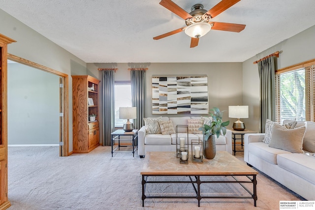 carpeted living room with ceiling fan and a textured ceiling