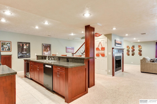 kitchen featuring a kitchen island with sink, a textured ceiling, sink, and light colored carpet