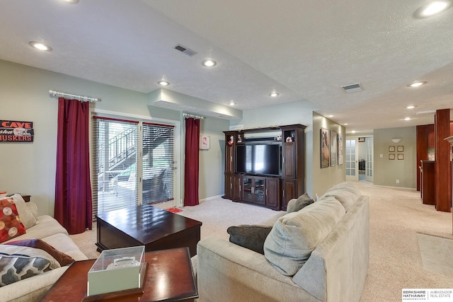 carpeted living room featuring a textured ceiling