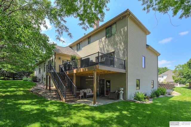 rear view of house featuring a wooden deck, a lawn, and a patio area