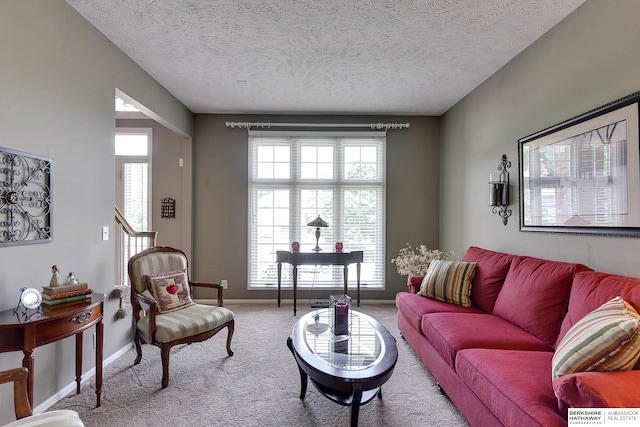 carpeted living room with a textured ceiling and a healthy amount of sunlight