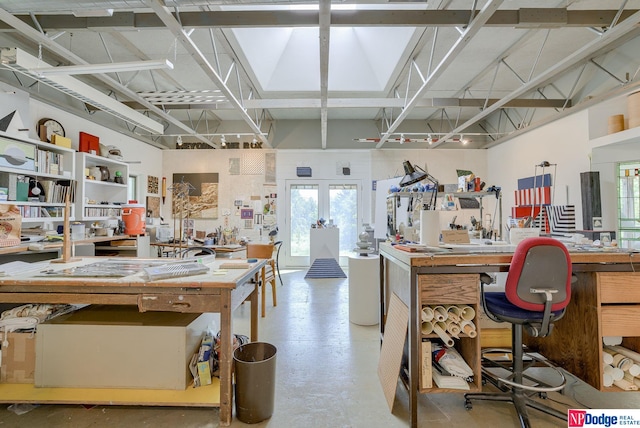 office with french doors, concrete floors, and a workshop area