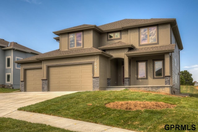 prairie-style home featuring a garage and a front yard