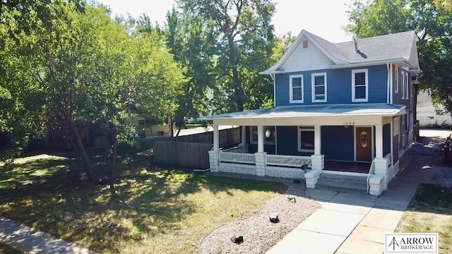 view of front of home featuring covered porch and a front lawn