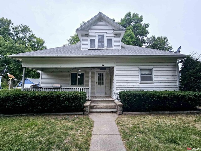 bungalow with a front yard and covered porch