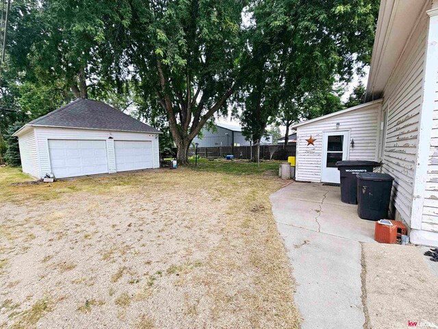 view of yard featuring a garage and an outbuilding