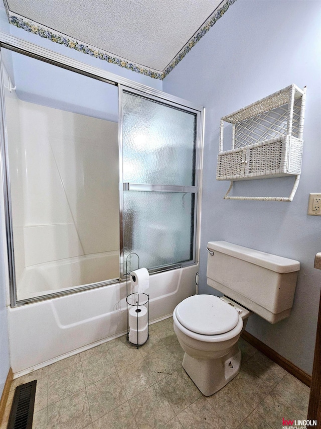 bathroom with a textured ceiling, toilet, and enclosed tub / shower combo