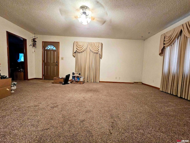 entrance foyer with a textured ceiling, carpet flooring, and ceiling fan