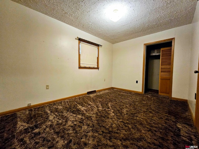 unfurnished bedroom with a textured ceiling and carpet floors