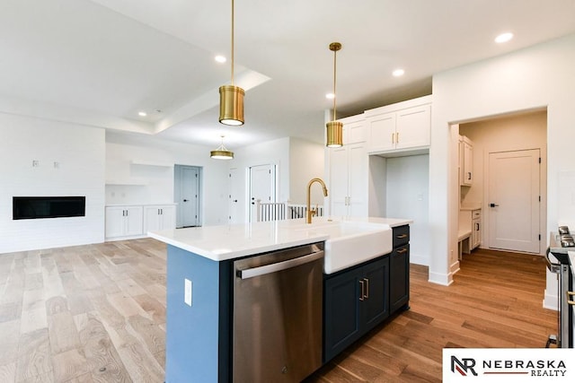 kitchen with white cabinets, appliances with stainless steel finishes, light countertops, light wood-type flooring, and recessed lighting