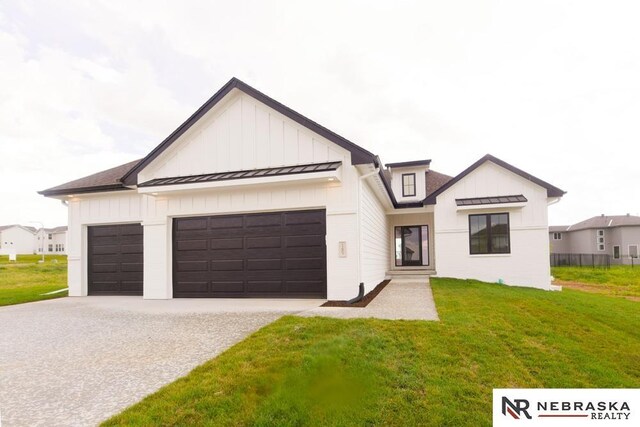 modern inspired farmhouse with a front lawn and a garage