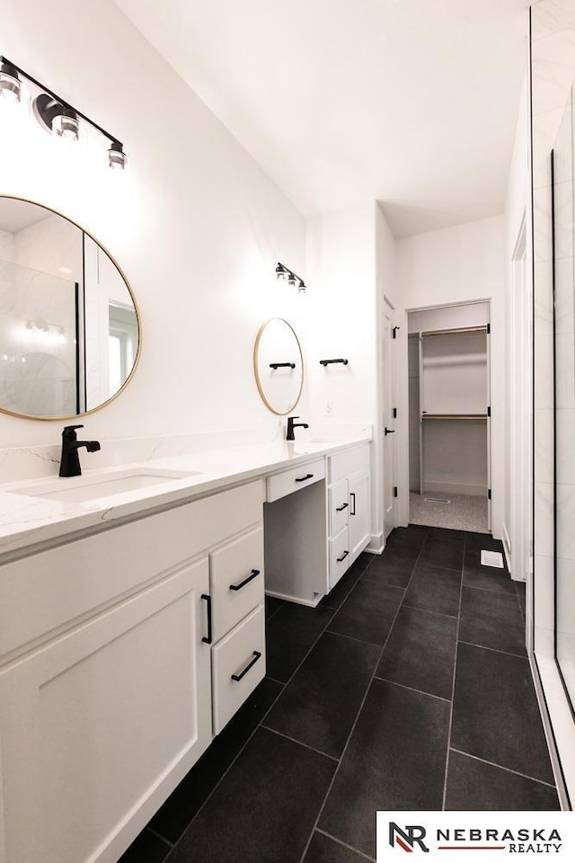 full bathroom with a stall shower, tile patterned flooring, vanity, and a spacious closet