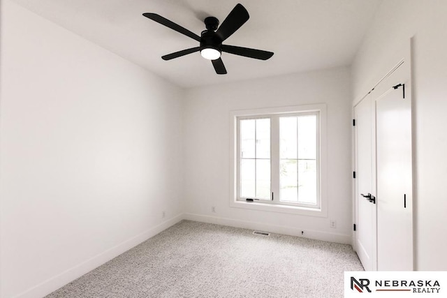 unfurnished bedroom with a ceiling fan, carpet, visible vents, and baseboards