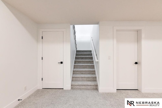 staircase featuring carpet floors and baseboards