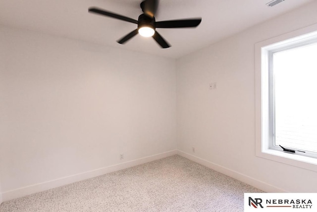 carpeted spare room with ceiling fan, visible vents, and baseboards