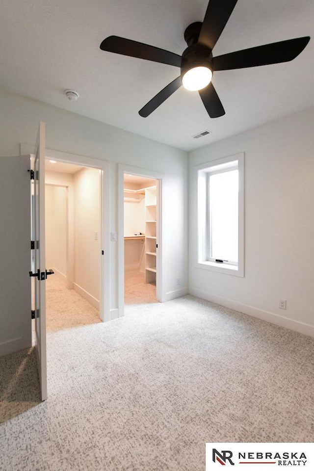 spare room featuring light carpet, baseboards, and visible vents