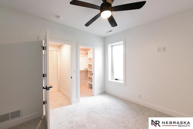 unfurnished bedroom with a ceiling fan, carpet, visible vents, and baseboards