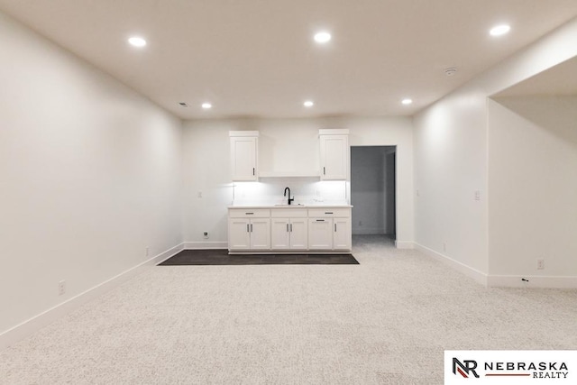 interior space with baseboards, carpet, recessed lighting, and white cabinets