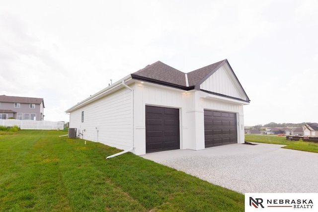 garage featuring driveway, fence, and central AC