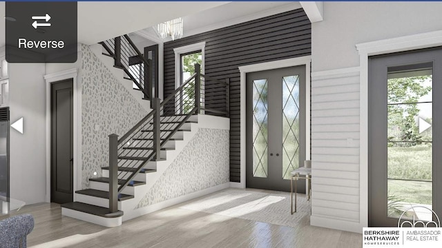 foyer featuring a wealth of natural light, wood finished floors, stairs, and wallpapered walls