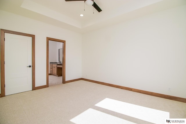 325 S Lakeview Way, Ashland, NE 68003 - unfurnished bedroom with light carpet, a tray ceiling, connected bathroom, recessed lighting, and a ceiling fan