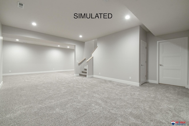 finished basement featuring carpet floors, stairs, visible vents, and recessed lighting