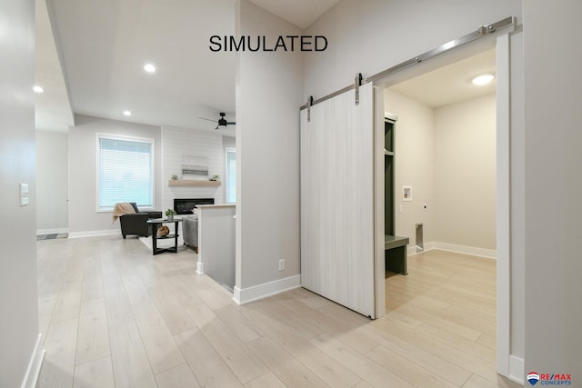 hall featuring a barn door and light hardwood / wood-style flooring