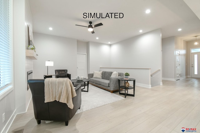 living area featuring a wealth of natural light, a fireplace, light wood-style flooring, and recessed lighting