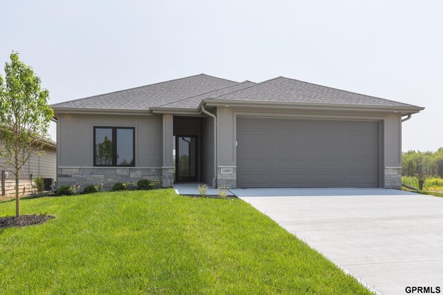 prairie-style house featuring a garage and a front yard