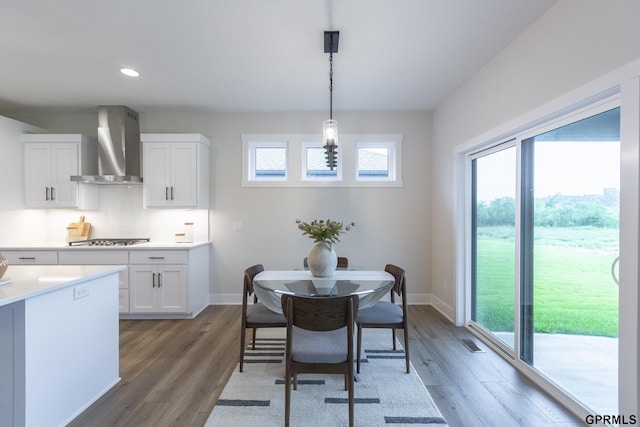 dining room with baseboards, light wood-style flooring, and a healthy amount of sunlight