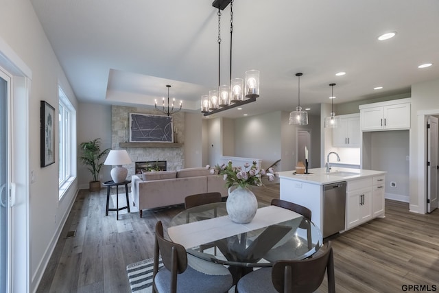 dining area featuring dark wood-style floors, recessed lighting, a fireplace, and baseboards