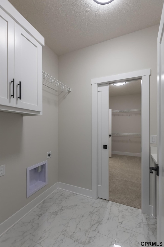 washroom featuring marble finish floor, hookup for an electric dryer, cabinet space, and baseboards