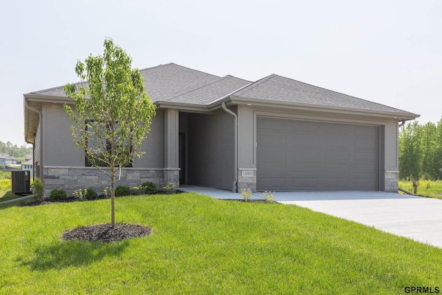 prairie-style house featuring stone siding, a shingled roof, and a front lawn